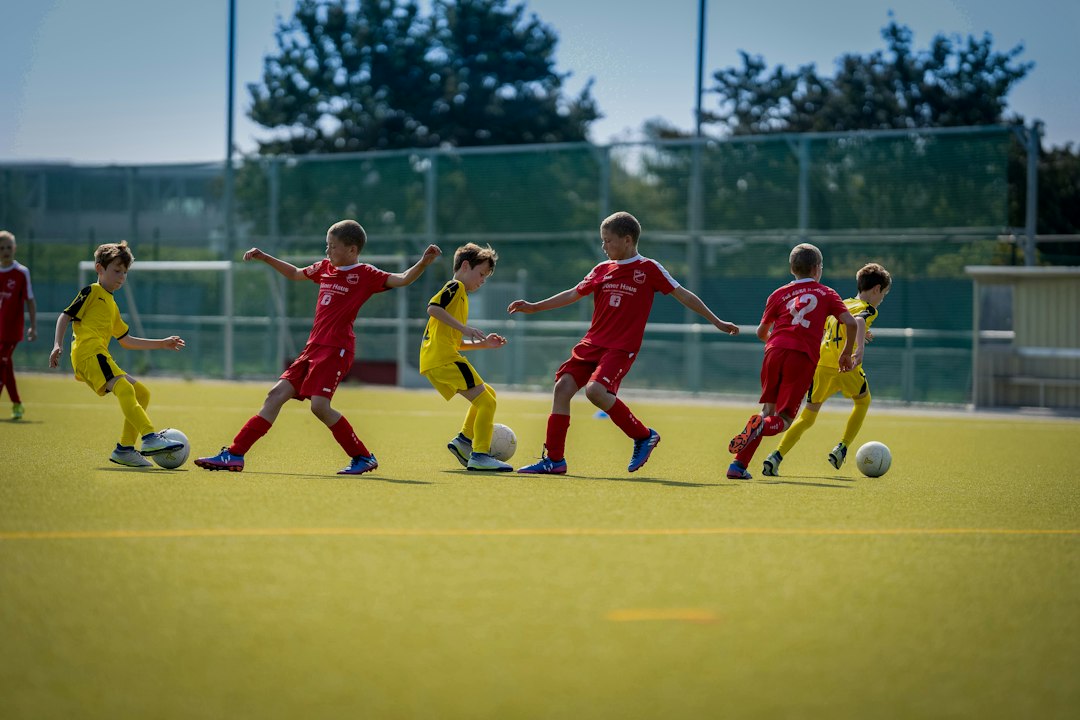 Crianças disputando bola em um treino de futebol na quadra
