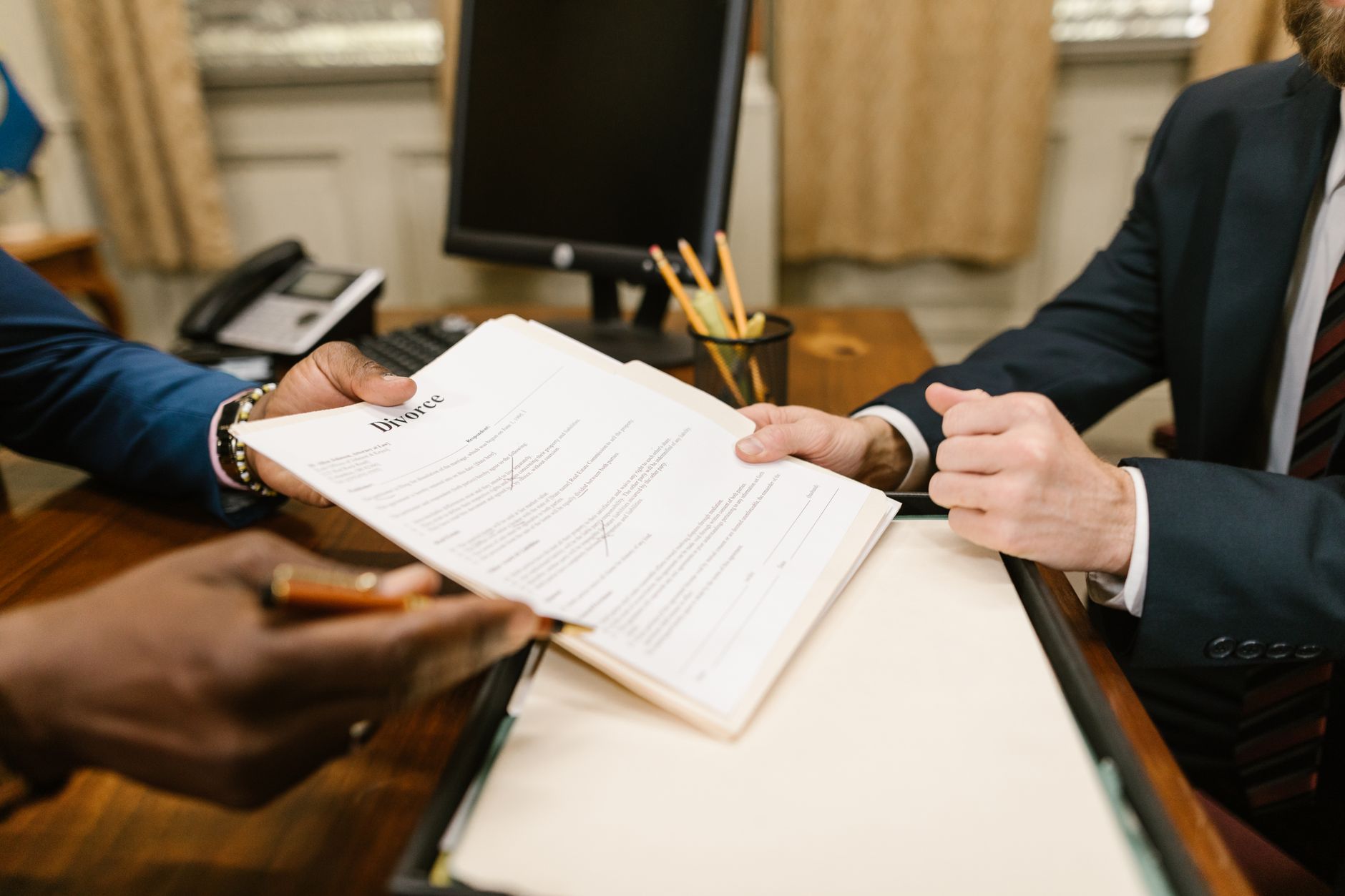 Duas pessoas trocando um contrato sobre a mesa